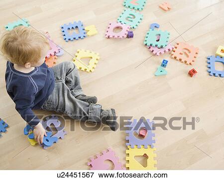Stock Photo - Young boy playing with toys. Fotosearch