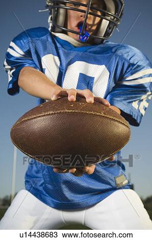 Young football player holding ball View Large Photo Image Stock Image - Young football player holding ball. Fotosearch