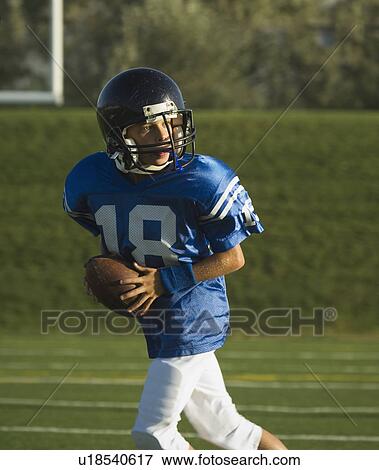 Young football player running with ball View Large Photo Image Stock Photo - Young football player running with ball. Fotosearch