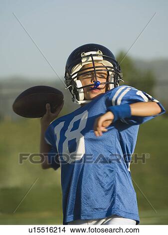 Picture - Young football player throwing ball. Fotosearch