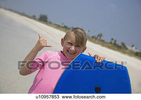 Stock Image - Young girl holding boogie board, Florida, United States. Fotosearch