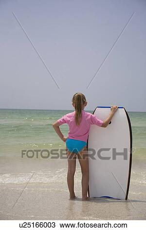 Young girl holding boogie board, Florida, United States View Large Photo Image Stock Image - Young girl holding boogie board, Florida, United States. Fotosearch