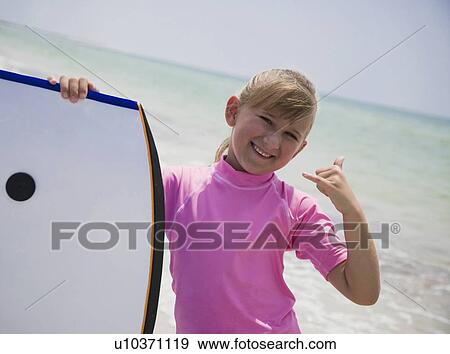 Stock Photo - Young girl holding boogie board, Florida, United States. Fotosearch