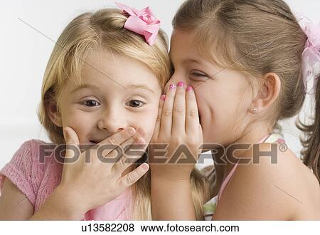 Young girl telling sister a secret View Large Photo Image Stock Photo - Young girl telling sister a secret. Fotosearch