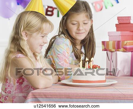 Young sisters with birthday cake at table View Large Photo Image Stock Photograph - Young sisters with birthday cake at table. Fotosearch