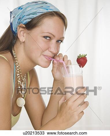 Young woman drinking smoothie with straw View Large Photo Image Stock Image - Young woman drinking smoothie with straw. Fotosearch