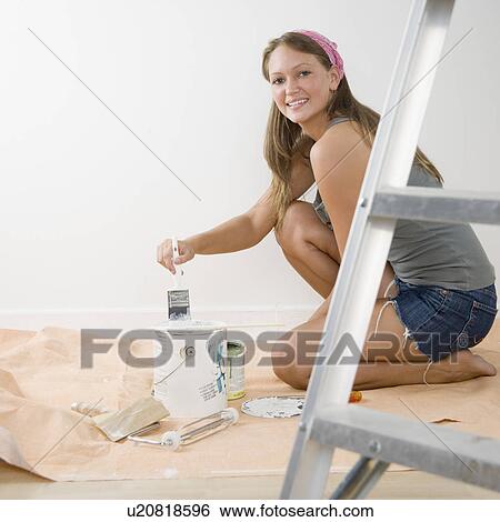 Young woman on tarp with paintbrush and paint can View Large Photo Image Stock Photograph - Young woman on tarp with paintbrush and paint can. Fotosearch