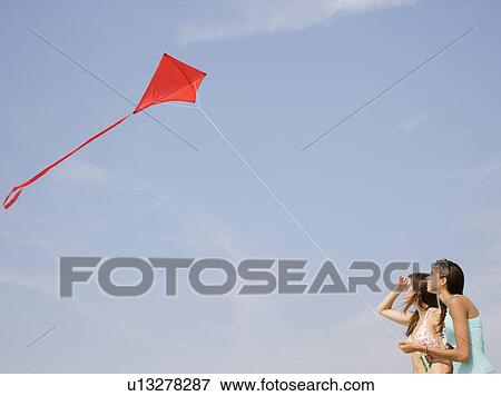 Young women flying kite View Large Photo Image Stock Photo - Young women flying kite. Fotosearch