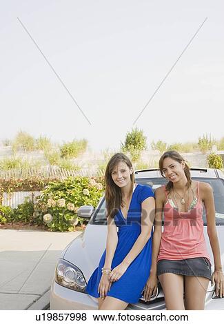 Young women sitting on car View Large Photo Image Stock Photo - Young women sitting on car. Fotosearch