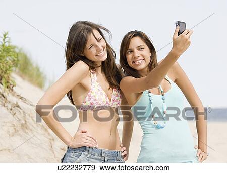 Young women taking own photograph View Large Photo Image Stock Photo - Young women taking own photograph. Fotosearch