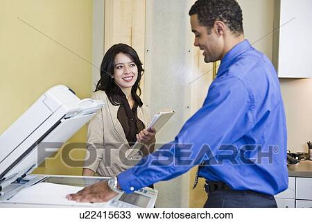 Stock Image - African businessman making photocopies. Fotosearch