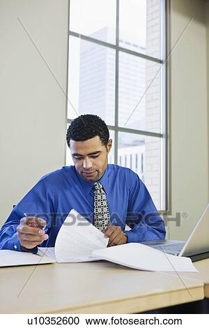 African businessman reading paperwork View Large Photo Image Stock Image - African businessman reading paperwork. Fotosearch