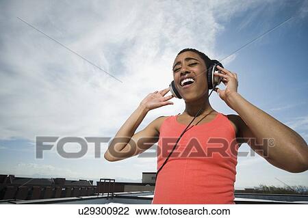 African woman listening to headphones View Large Photo Image Stock Image - African woman listening to headphones. Fotosearch