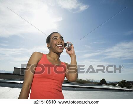 Stock Image - African woman talking on cell phone. Fotosearch