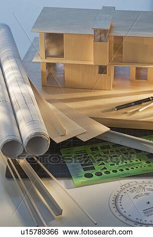 Stock Photograph - Architect blueprints, model house, and measuring equipment. Fotosearch