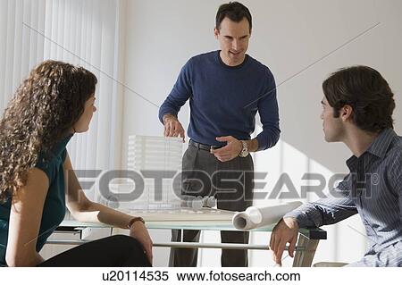 Stock Photography - Architect presenting building model to clients. Fotosearch