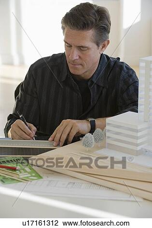 Stock Image - Architect working on building model. Fotosearch