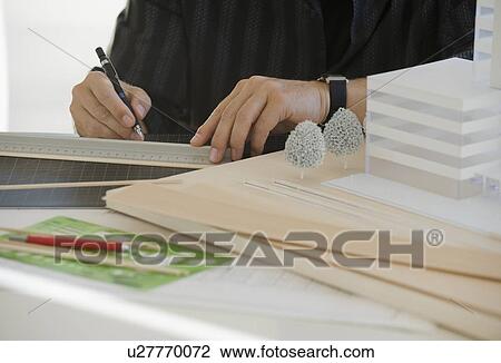 Stock Image - Architect working on building model. Fotosearch