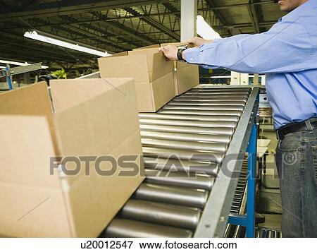 Stock Photo - Asian male factory worker checking product. Fotosearch