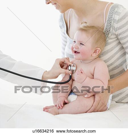 Baby being examined by doctor View Large Photo Image Stock Photograph - Baby being examined by doctor. Fotosearch