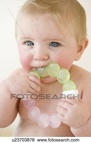Stock Photo - Baby biting on teething ring. Fotosearch