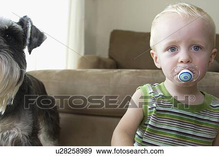 Stock Photo - Baby boy sucking on pacifier. Fotosearch
