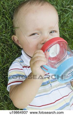 Baby laying in grass View Large Photo Image Stock Photo - Baby laying in grass. Fotosearch