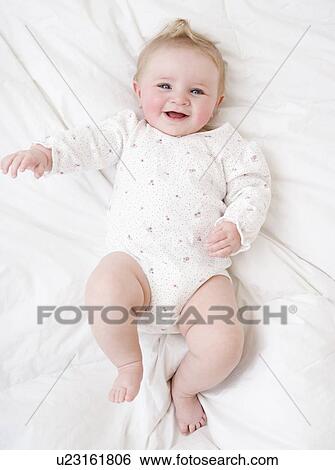 Baby laying on bed View Large Photo Image Stock Photograph - Baby laying on bed. Fotosearch