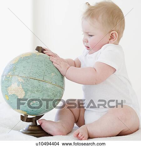 Picture - Baby looking at globe. Fotosearch