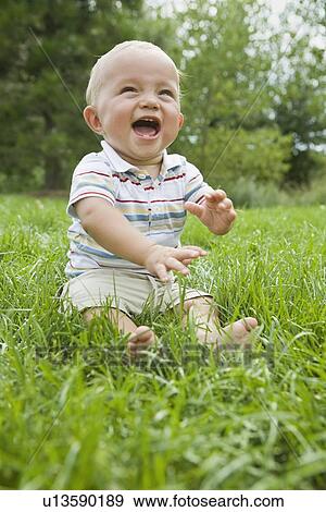 Baby sitting in grass View Large Photo Image Stock Photo - Baby sitting in grass. Fotosearch