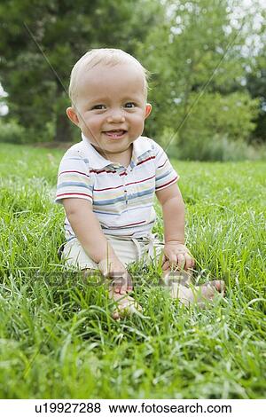 Stock Photo - Baby sitting in grass. Fotosearch