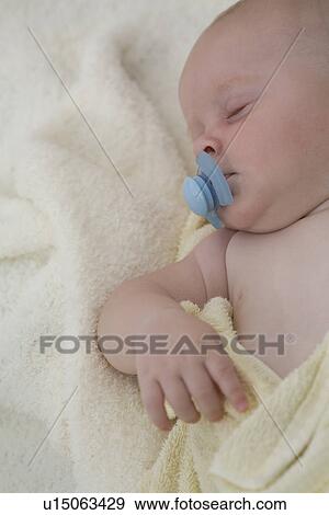 Stock Photo - Baby sleeping with pacifier in mouth. Fotosearch
