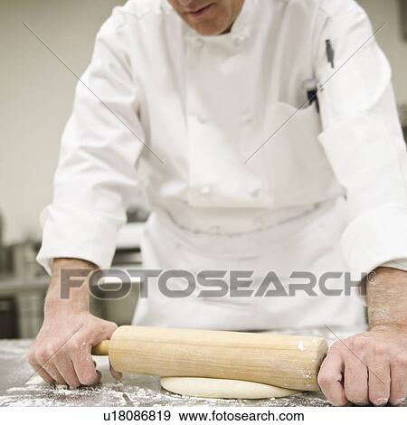 Stock Photo - Baker rolling dough. Fotosearch