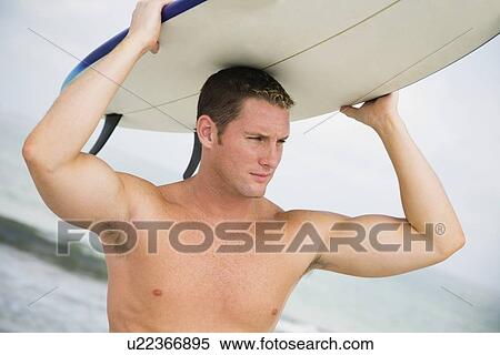 Bare-chested man holding surfboard View Large Photo Image Stock Photography - Bare-chested man holding surfboard. Fotosearch