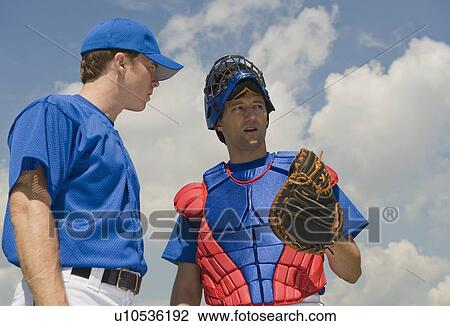Stock Image - Baseball pitcher and catcher conferring about pitch. Fotosearch