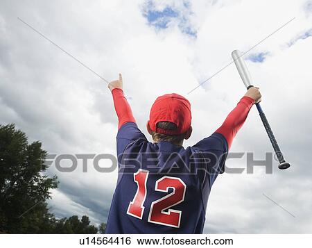 Stock Photograph - Baseball player celebrating with arms raised. Fotosearch