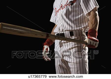 Stock Photo - Baseball player holding bat. Fotosearch