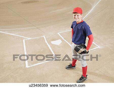 Stock Photo - Baseball player in uniform posing by home plate. Fotosearch
