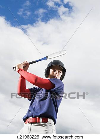 Stock Photograph - Baseball player reading to swing bat. Fotosearch