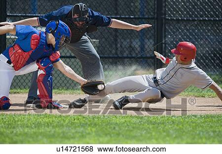 Stock Photo - Baseball player sliding into home plate. Fotosearch