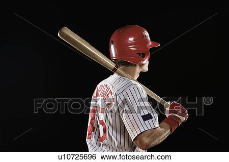 Stock Photograph - Baseball player standing with bat. Fotosearch