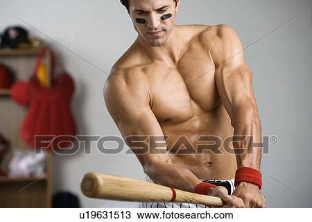 Stock Image - Baseball player with bare chest warming up with bat. Fotosearch