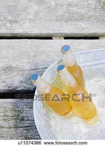 Stock Photograph - Beer bottles in bucket of ice. Fotosearch