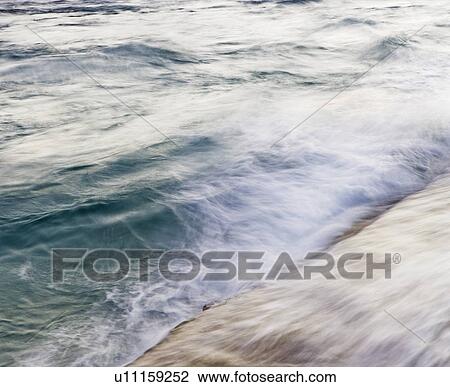 Stock Image - Blurred motion shot of ocean waves. Fotosearch