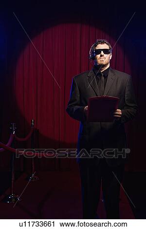 Bouncer with guest list standing near velvet rope View Large Photo Image Stock Image - Bouncer with guest list standing near velvet rope. Fotosearch