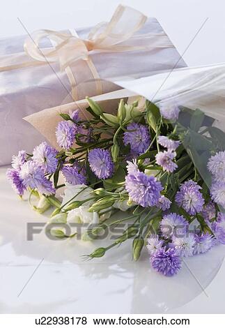 Stock Photo - Bouquet of flowers and gift. Fotosearch