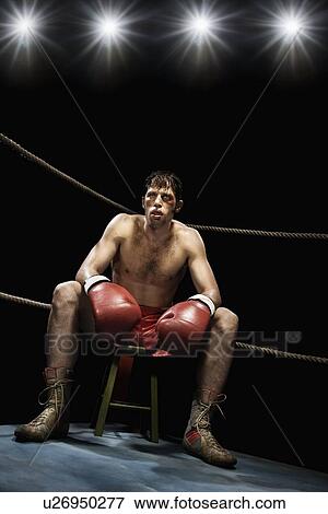 Stock Photo - Boxer sitting on stool in corner of boxing ring. Fotosearch