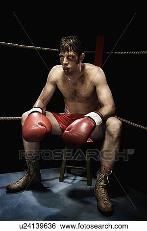 Stock Photograph - Boxer sitting on stool in corner of boxing ring. Fotosearch
