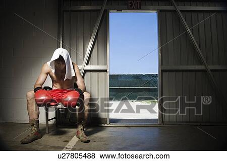 Stock Photo - Boxer sitting on stool near doorway. Fotosearch