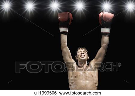 Stock Photograph - Boxer smiling with boxing gloves raised. Fotosearch